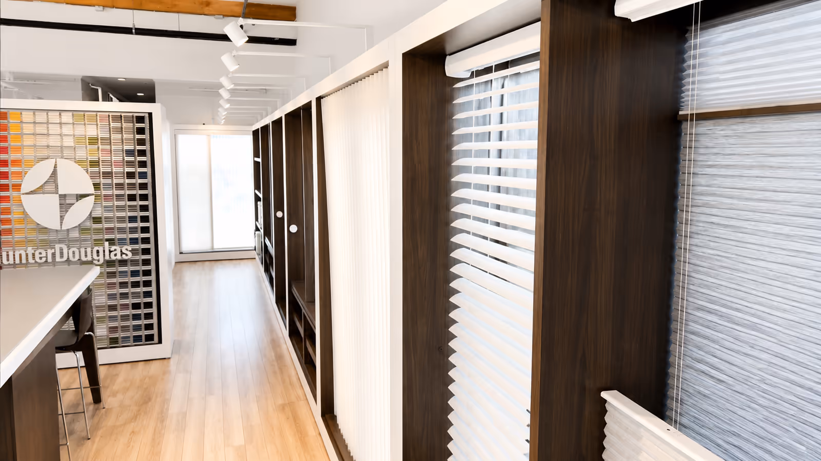 Inside the La Grange Window Coverings Windsor showroom — Hunter Douglas sample wall with wood blinds, vertical sheers, and cellular shade displays