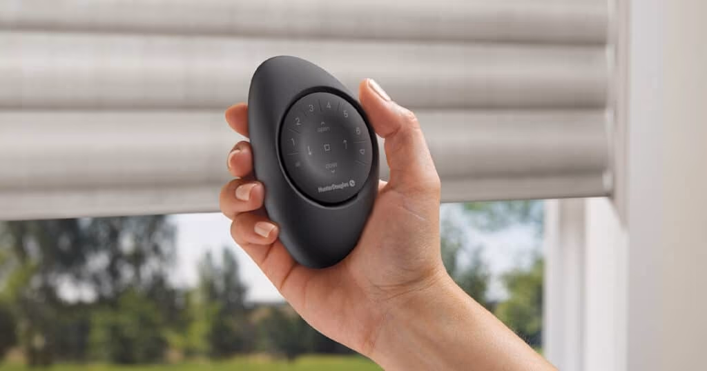 Hunter Douglas PowerView Pebble Remote controlling motorized faux-wood blinds in a Sonoma County living room by La Grange Window Coverings